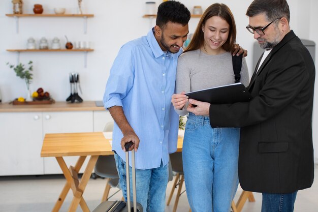 Renting a Fully Equipped NYC Residence for Weddings or Event 3 Travelers are discussing booking details with the property manager in a furnished apartment while checking documents together.